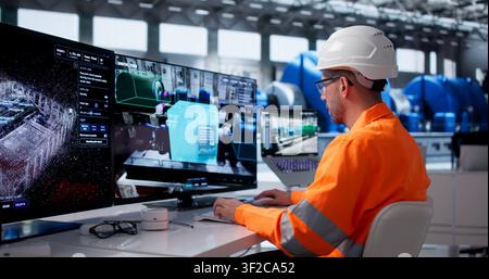 Young Engineer Monitors Real-time Industrial Data On Smart Control Room Screens. Stock Photo