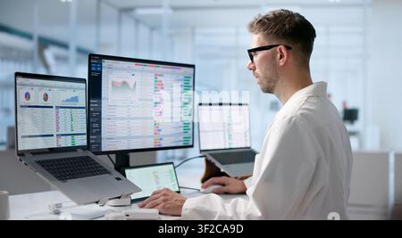 Young Man Reviews Medical Billing Codes On Laptop For Healthcare Compliance. Stock Photo