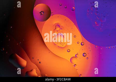 Abstract orange and purple oil bubbles mixing in water creating a beautiful texture Stock Photo