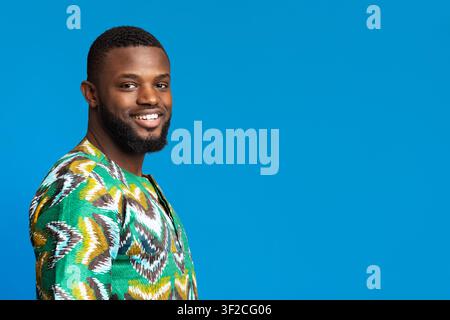 Positive black man in african shirt looking at camera Stock Photo