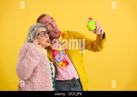 Cheerful mature couple making funny faces capturing a selfie Stock Photo