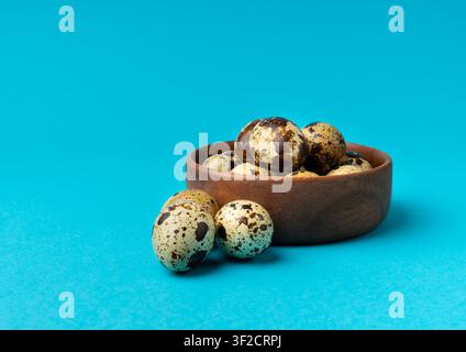 Quail Eggs, Diet Egg in Wood Bowl, Healthy Breakfast, Natural Organic Nutrition, Salad Ingredient Spotted Quail Egg on Blue Background Stock Photo