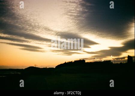Dramatic Sunset Over a Rural Landscape With Dark Clouds Stock Photo