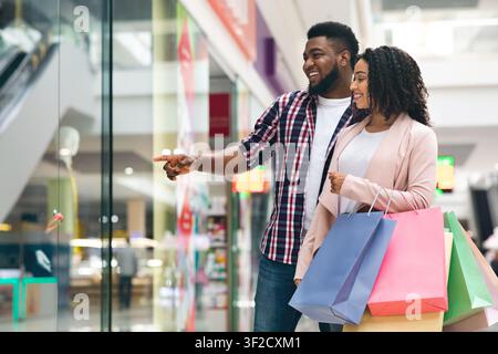 Consumerism Concept. Happy Black Spouses Shopping Together In Department Store Stock Photo
