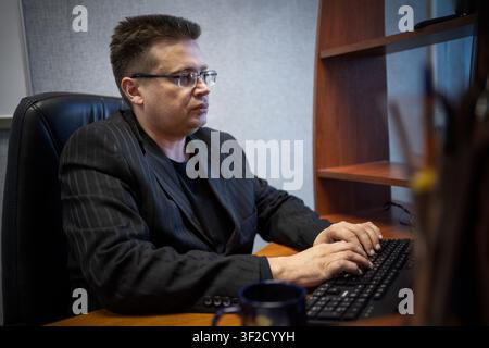 businessman concentrating on computer work, looking at laptop screen, thinking. focused reading of information on a PC in the office. The manager is a Stock Photo