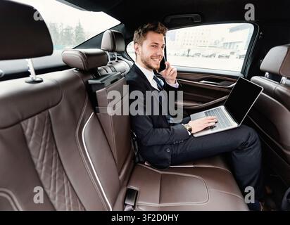 Young businessman talking on smart phone in car Stock Photo