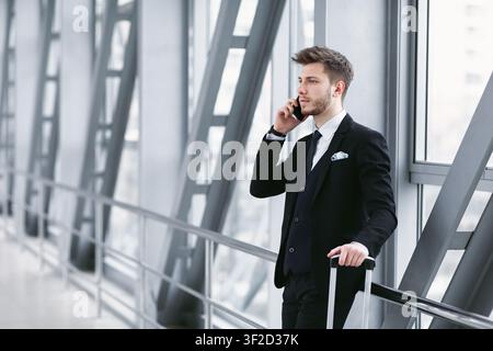 Serious business man talking on smartphone in airport Stock Photo