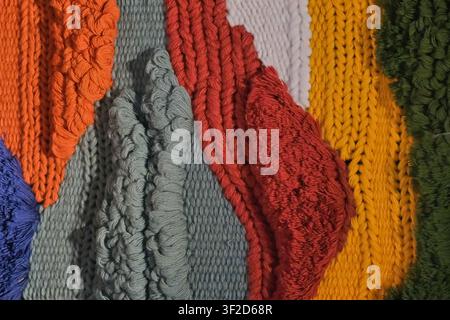 Colorful yarn and woven textile fiber samples of knitted textures, loops, handmade patterns. Creative background for textile design, weaving, crafts  Stock Photo
