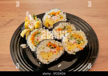 Homemade Kimbap Sliced and Served on Black Plate Stock Photo