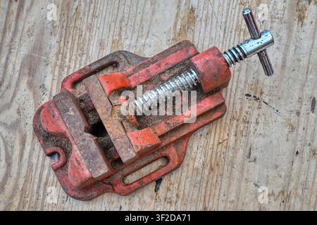 Rusty old vice on weathered wooden workbench top Stock Photo