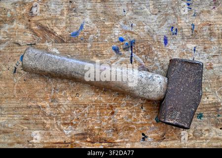 Rusty old mallet on weathered wooden workbench top Stock Photo