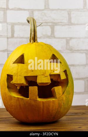 Spooky Halloween pumpkin jack-o-lantern on a wooden background Stock Photo