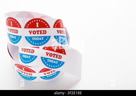 Roll of red white and blue I voted stickers with American flag Stock Photo