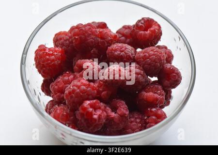 Fresh ripe raspberries in a glass bowl on a white background Stock Photo