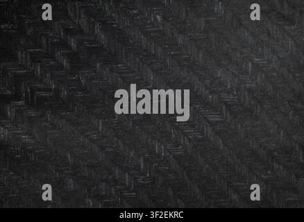 Dark black woven material texture herringbone pattern low key surface detail moody monochrome look. Abstract background design texture overlay, poster Stock Photo