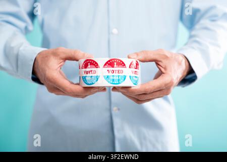 Unrecognizable man holding roll with stickers for voters Stock Photo