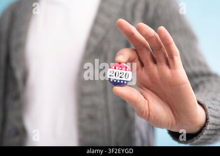 Incognito voter holding vote button on blue background Stock Photo
