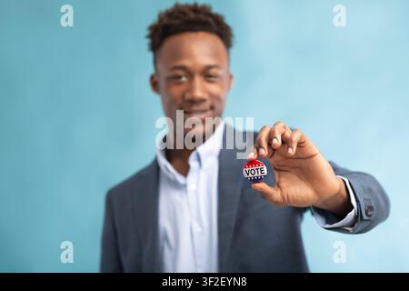 African american Man with Vote button on blue Stock Photo