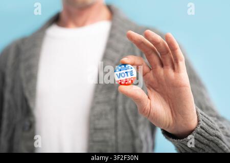 Law abiding american citizen holding vote pin in hand Stock Photo