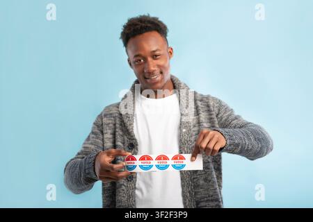 Happy african american man holding roll with stickers Stock Photo