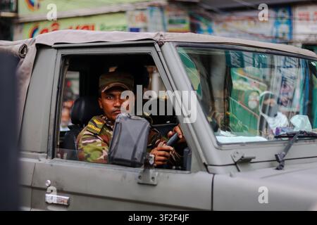Feni, Bangladesh - 07 August 2024: View of a soldier in camouflage uniform driving a military vehicle in an urban setting. Stock Photo