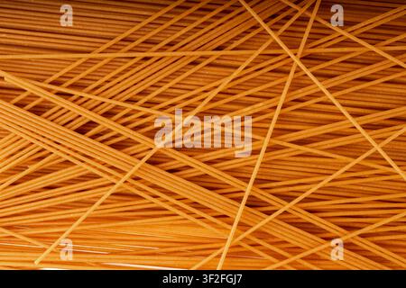 Raw wholegrain brown spaghetti macro texture, dry spagetti pattern, long wheat noodles banner, uncooked italian macaroni pasta closeup Stock Photo