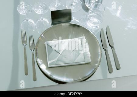Elegant restaurant table setting with plates cutlery and crystal glasses Stock Photo