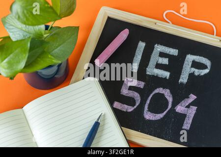 IEP 504 Handwritten in chalk on a school blackboard, Individual education plan, Business concept, IEP 504 program, copy space, Text on natural wooden Stock Photo