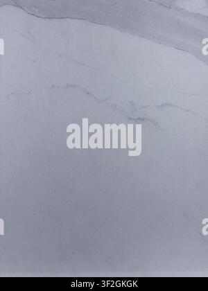 Pale white marble surface with delicate gray veins and elegant natural stone texture Stock Photo
