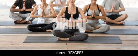 Healthy Lifestyle. Diverse young people exercising yoga together, sitting in lotus position Stock Photo