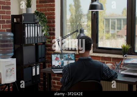 Accountant speaks with colleagues on online video call in office, financial consultant uses remote videoconference to chat with workmates about business strategy, planning startup project. Stock Photo