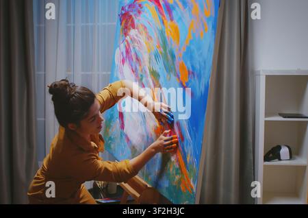 Painter making a masterpiece in creative art studio while renovating an apartment, using painting supplies and repair planning for interior maintenance and home improvement. Stock Photo