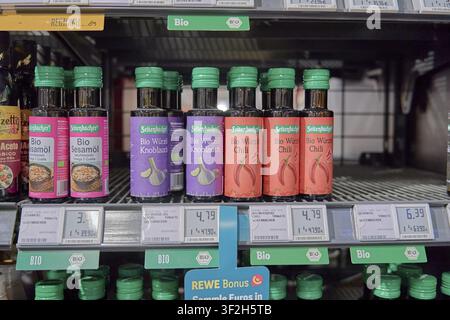 Root oils such as organic garlic and chilli oil on supermarket shelves, holding product in hand, Seitenbacher oil, shopping in supermarket, shop, Rewe Stock Photo