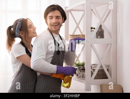 Young Romantic Couple Doing Housework At Home Together, Hugging And Smiling Stock Photo