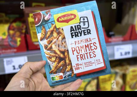Hand holding pack of MaGi pepper fries on supermarket shelf, Penny food discounter Stock Photo