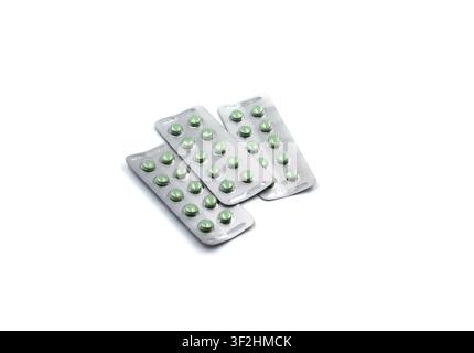 Three blister packs with round green pills on white background Stock Photo