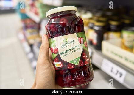 Glass with sour cherries in the supermarket. The labeling shows red fruits from the brand Greenland, which are individually slightly sweetened, Penny Stock Photo