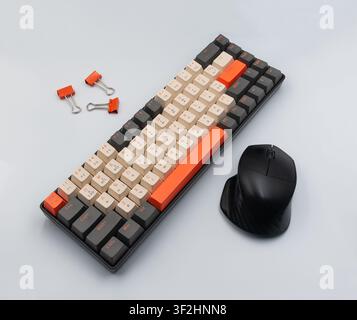 Mechanical gaming keyboard with mouse and paper clips on gray surface Stock Photo