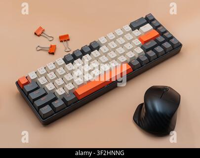 Mechanical keyboard with computer mouse and binder clips on beige background Stock Photo