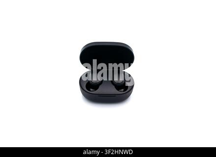 Black wireless headphones in a charging case on a white background Stock Photo