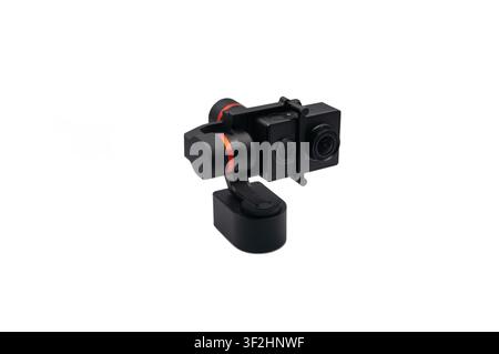 A black digital action camera secured in a 3-axis motorized handheld gimbal stabilizer, isolated on a clean white background. Stock Photo