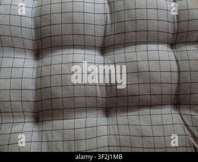 Soft gray tufted fabric with classic black grid pattern. Great for sofa, chair, and bedding texture backgrounds. Stock Photo