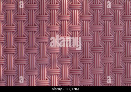 Detailed macro of pink woven plastic rattan pattern with geometric interlaced design for modern background Stock Photo