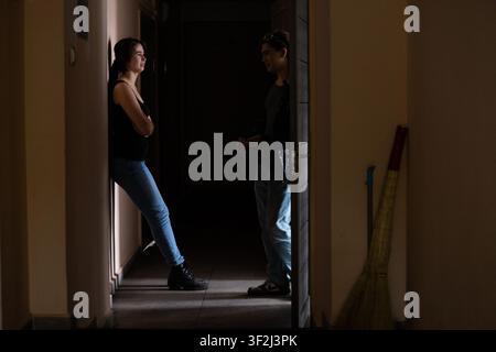 Silhouette of students talking in a dark hallway Stock Photo