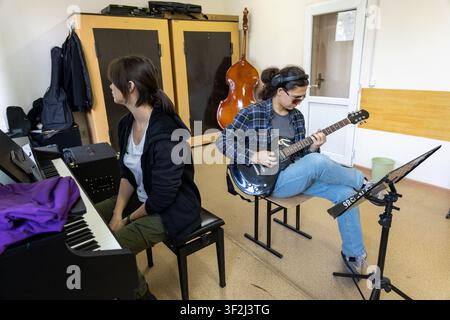 Music students rehearsing together in classroom Stock Photo