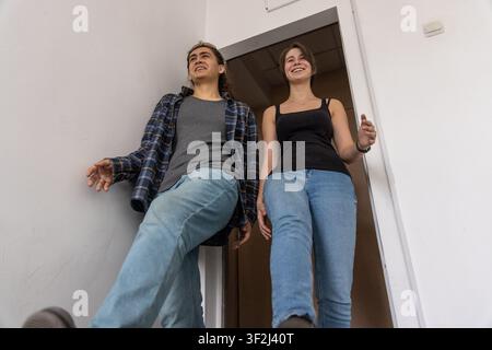 Happy students walking down the stairs low angle Stock Photo
