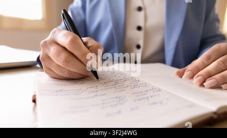 Closeup businesswoman writing, taking notes with pen in notebook Stock Photo