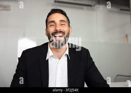 Latin businessman participating in discussion through video call, portrait Stock Photo