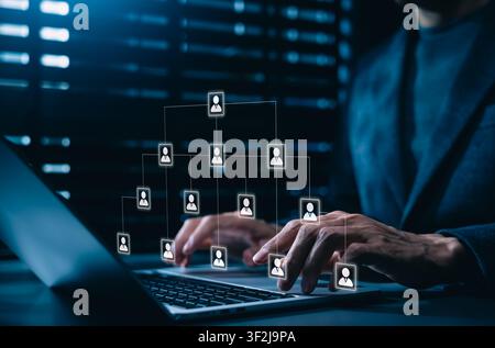Corporate hierarchy chart and human resources structure concept. Business manager using laptop with corporate organizational scheme with people profil Stock Photo