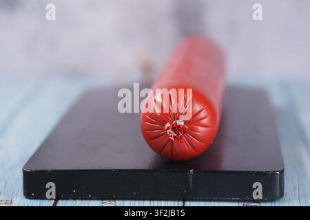 Sausage on a black cutting board in a kitchen Stock Photo